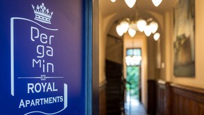 A sign for "Perga Min Royal Apartments" with a staircase in the background. - G12 Aparthotel (Kraków)