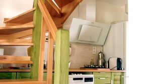 A kitchen with a wooden staircase leading to a lofted area. - Pia Aparts (Kemer)