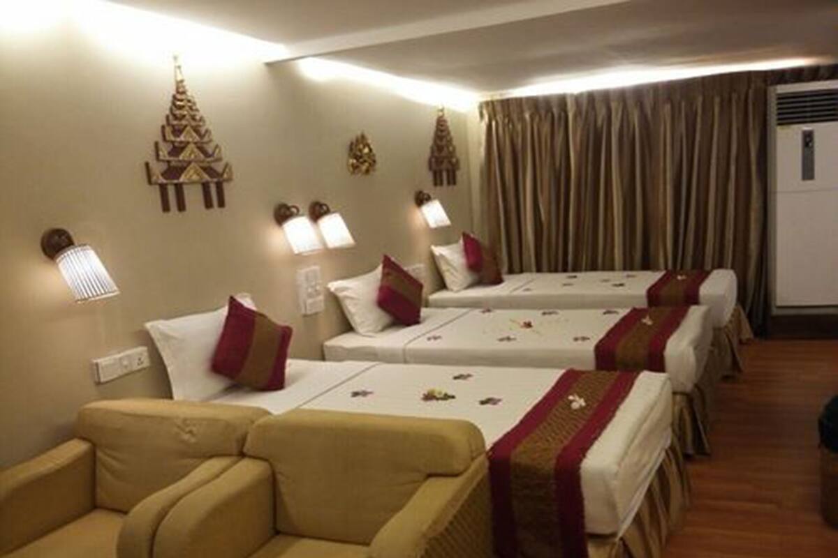 Ein Hotelzimmer mit zwei Betten, einem Schlafsofa und Wandkunst.