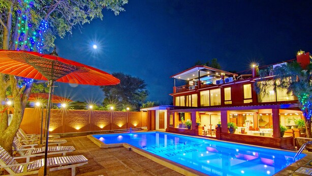 A two-story building with a swimming pool, outdoor seating, and string lights. - Hotel Yadanarbon Bagan (Nyaung-U)