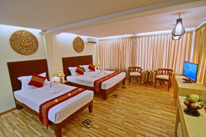 A hotel room with two beds, a desk, a chair, a television, and a decorative wall piece. - Hotel Yadanarbon Bagan (Nyaung-U)