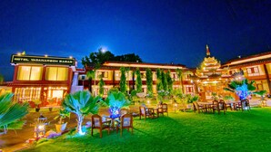 A hotel with a traditional architectural style, featuring multiple dining areas with outdoor seating, a well-lit entrance, and a large sign displaying the hotel's name. - Hotel Yadanarbon Bagan (Nyaung-U)