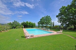 Una piscina al aire libre, sombrillas, tumbonas