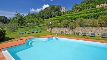 Alberca al aire libre y camastros