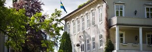 A building with a balcony and a flag. - Krokstad Herrgård (Saffle)