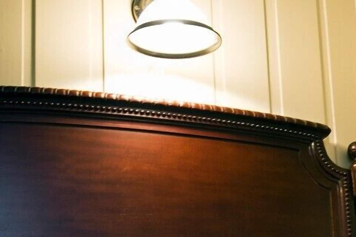 Un mueble de madera con una lámpara sobre él.