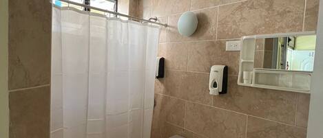 Un baño pequeño con inodoro, lavamanos y cortina de ducha.