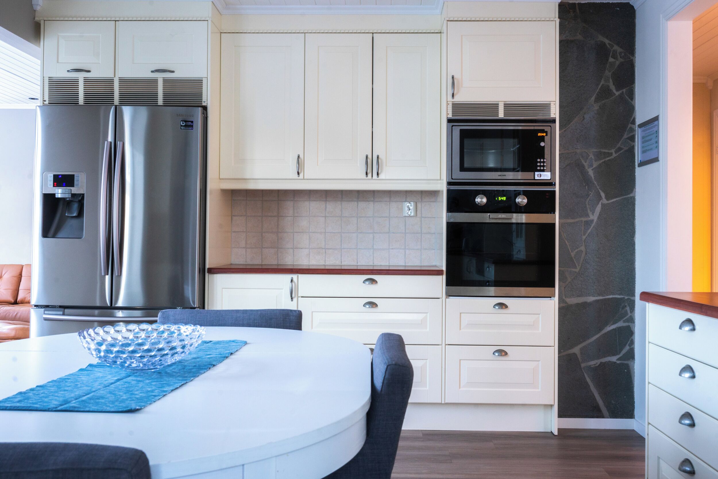Una cocina moderna con refrigerador, horno y microondas incorporados.