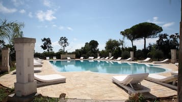 Een buitenzwembad, parasols voor strand/zwembad