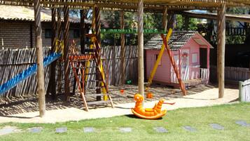 Children can play and explore in this outdoor play area featuring a swing set, slide, and climbing structure.