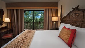 A hotel room with a large bed, two bedside lamps, a wooden headboard, and a view of trees through a balcony door. - Disney's Animal Kingdom Villas - Jambo House (Kissimmee)