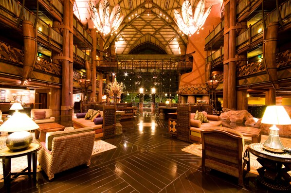A spacious lobby with high ceilings, ornate wooden railings, and multiple seating areas. - Disney's Animal Kingdom Villas - Jambo House (Kissimmee)