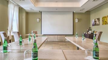 A conference room with a long table, chairs, and a projector screen.