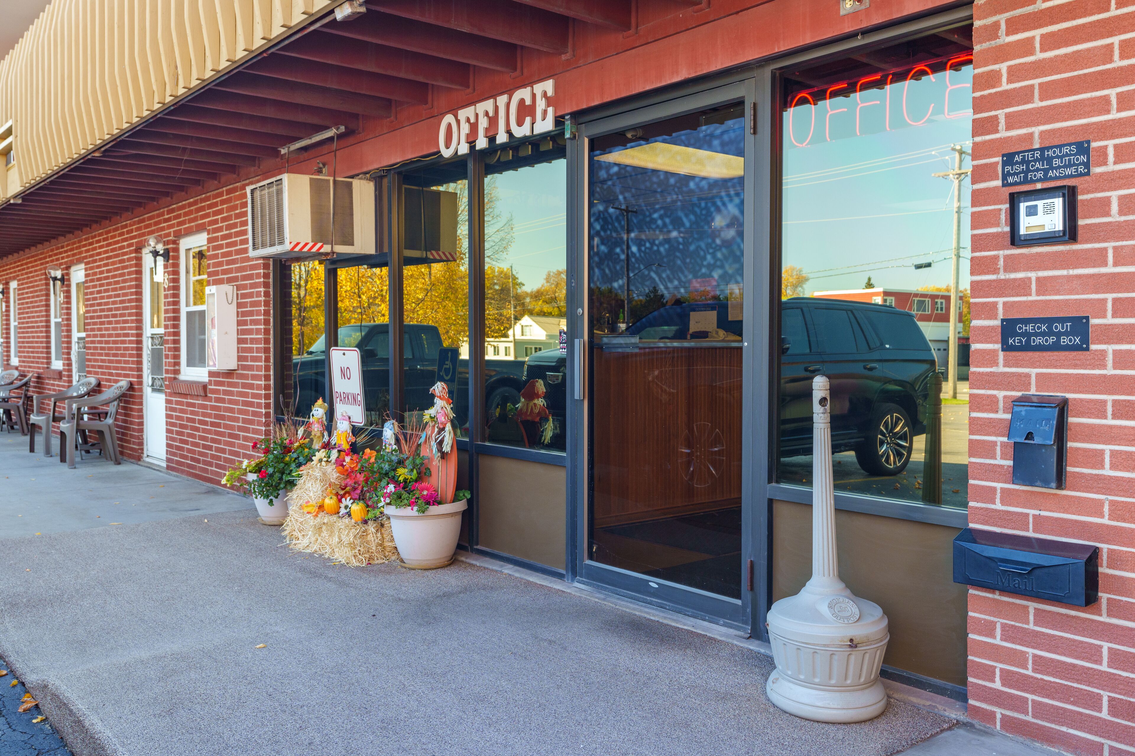 A brick building with a large glass entrance labeled "OFFICE".