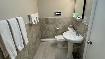 Une petite salle de bain comprenant des toilettes, un lavabo et un porte-serviettes.