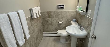 Ein kleines Badezimmer mit Toilette, Waschbecken und Handtuchhalter.