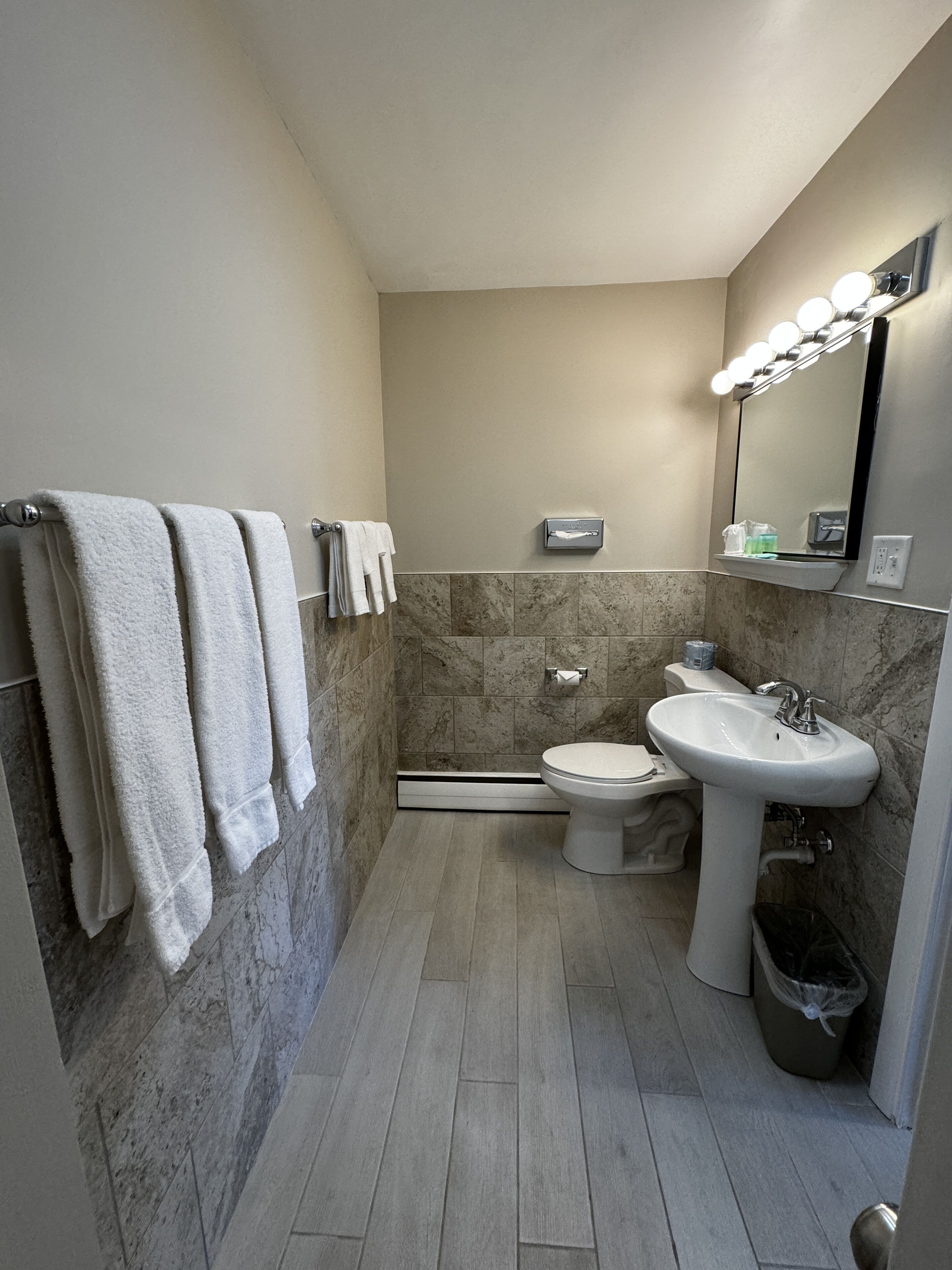 A modern bathroom with a toilet, sink, and towel rack.