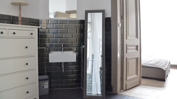 A bathroom with a white cabinet, a sink, and a mirror. - Amazing Apartment Antwerp South (Antwerp)