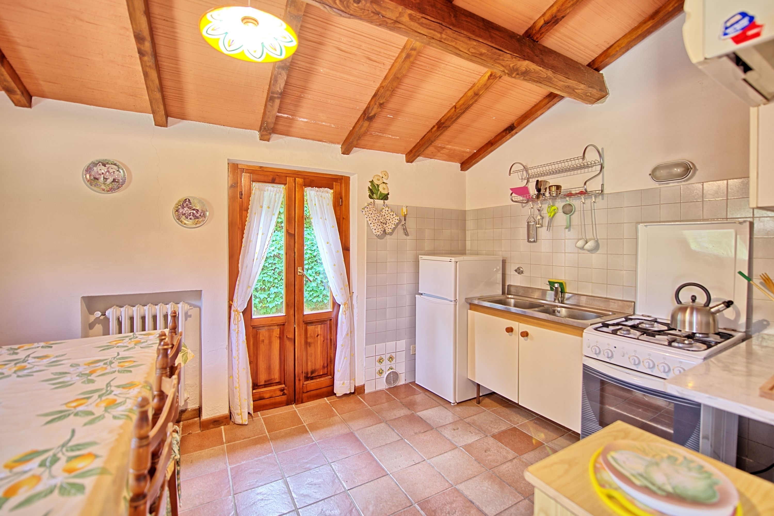A compact kitchen with a stove, sink, and refrigerator.