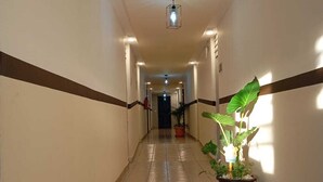 A long, narrow hallway with tiled floors and walls, lined with potted plants and recessed lighting. - Hotel Esperanza (Mazatlán)