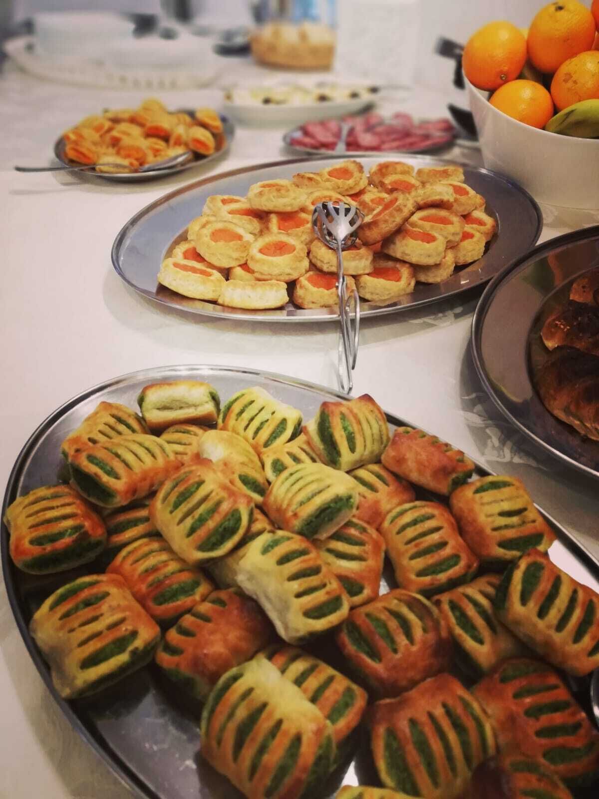 A buffet with various food items including pastries and fruits.