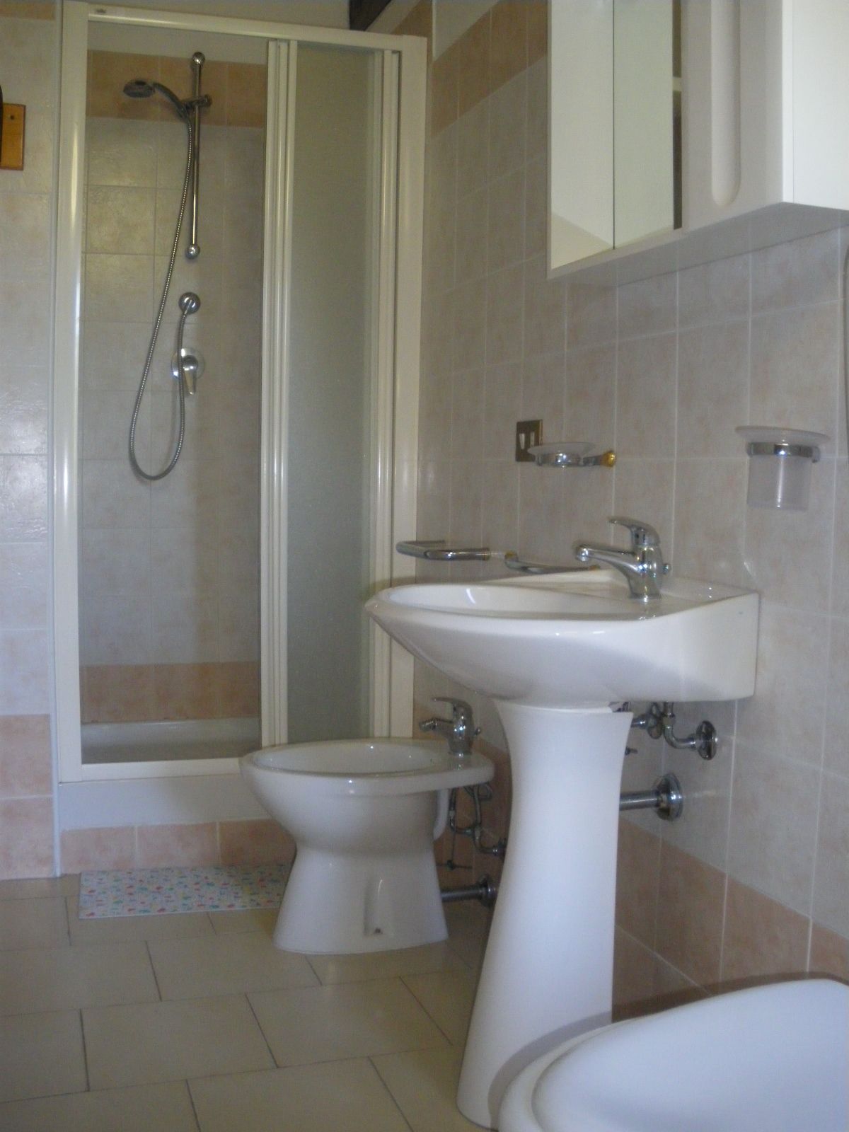 Ein Badezimmer mit Dusche, Waschbecken und Toilette.