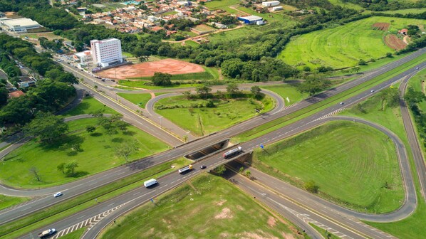 An aerial view of a highway interchange with multiple lanes and a large building in the background.