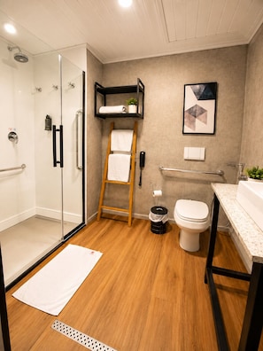 A modern bathroom with a glass shower enclosure, a wooden ladder, a toilet, and a sink with a countertop. - ibis Catanduva (Catanduva)