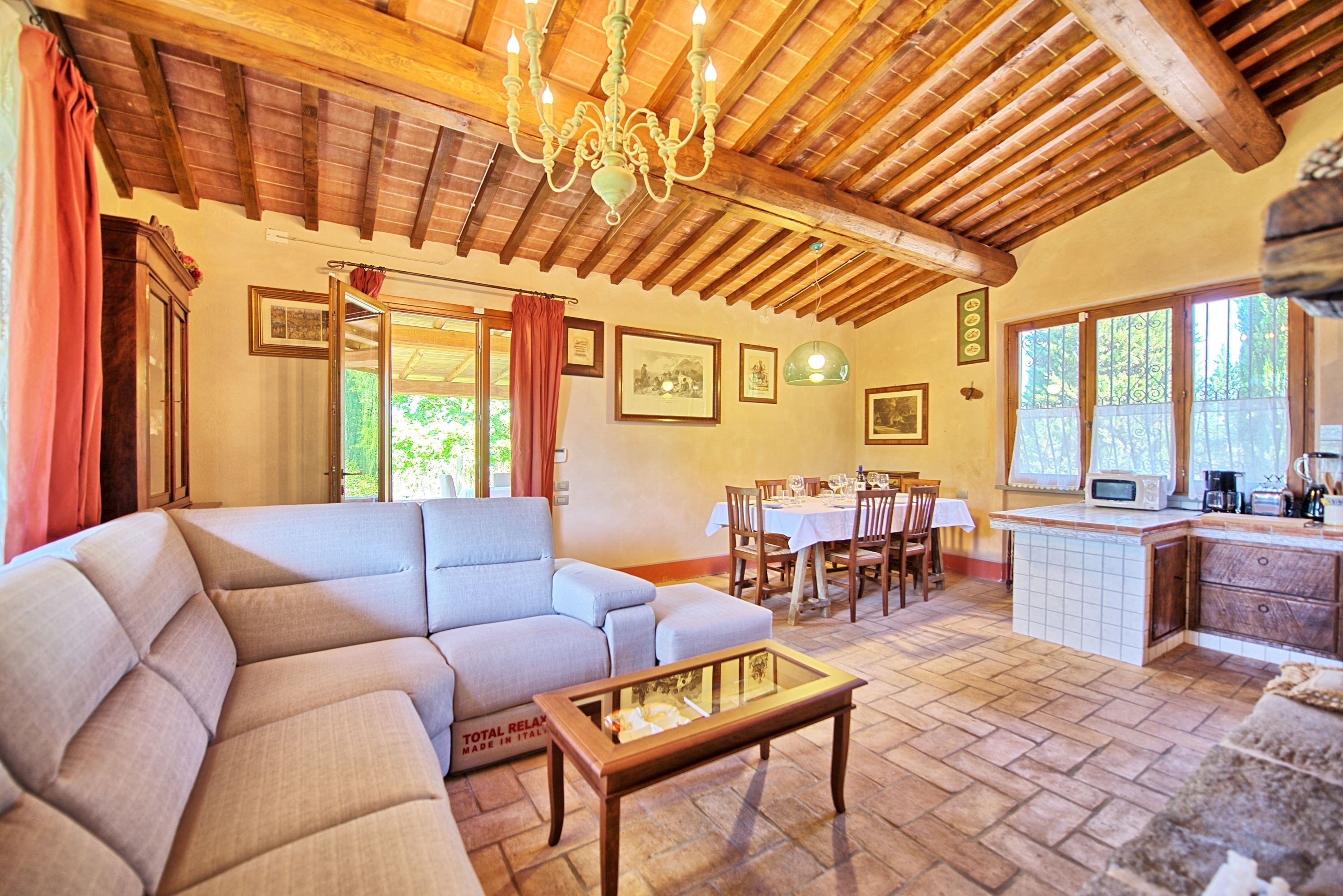 A cozy living room with a sectional sofa, a wooden coffee table, and a dining area with a table and chairs.