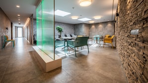Un interior moderno con una recepción, una zona de estar y una pared de piedra.