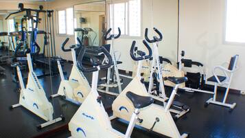 A gym with stationary bikes, a treadmill, and exercise equipment.
