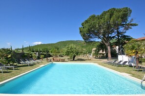 Una piscina al aire libre de temporada, sillones reclinables de piscina