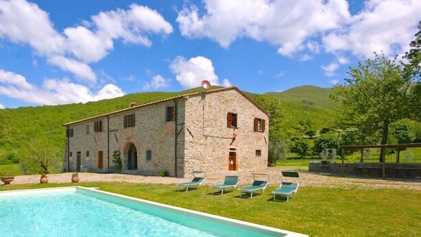 A stone building with a swimming pool and lounge chairs. - Villa Poggiolino (Subbiano)