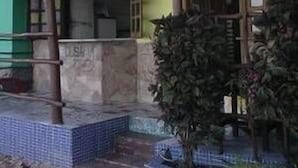 Un edificio de dos pisos con un balcón y una entrada con azulejos.