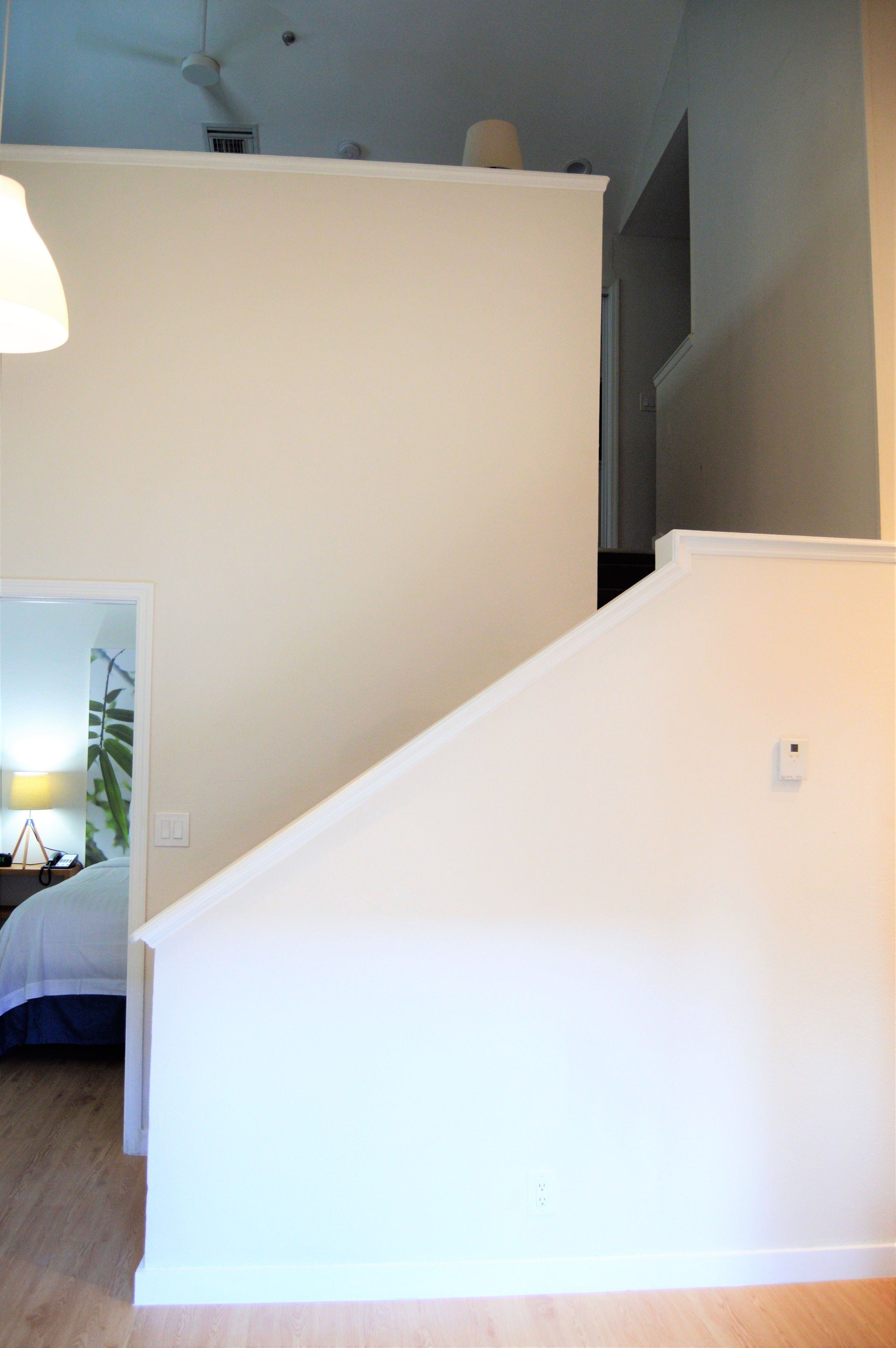 A staircase with white walls and a wooden floor.