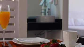 Desayuno con un vaso de jugo de naranja, una taza blanca y un plato de fresas.