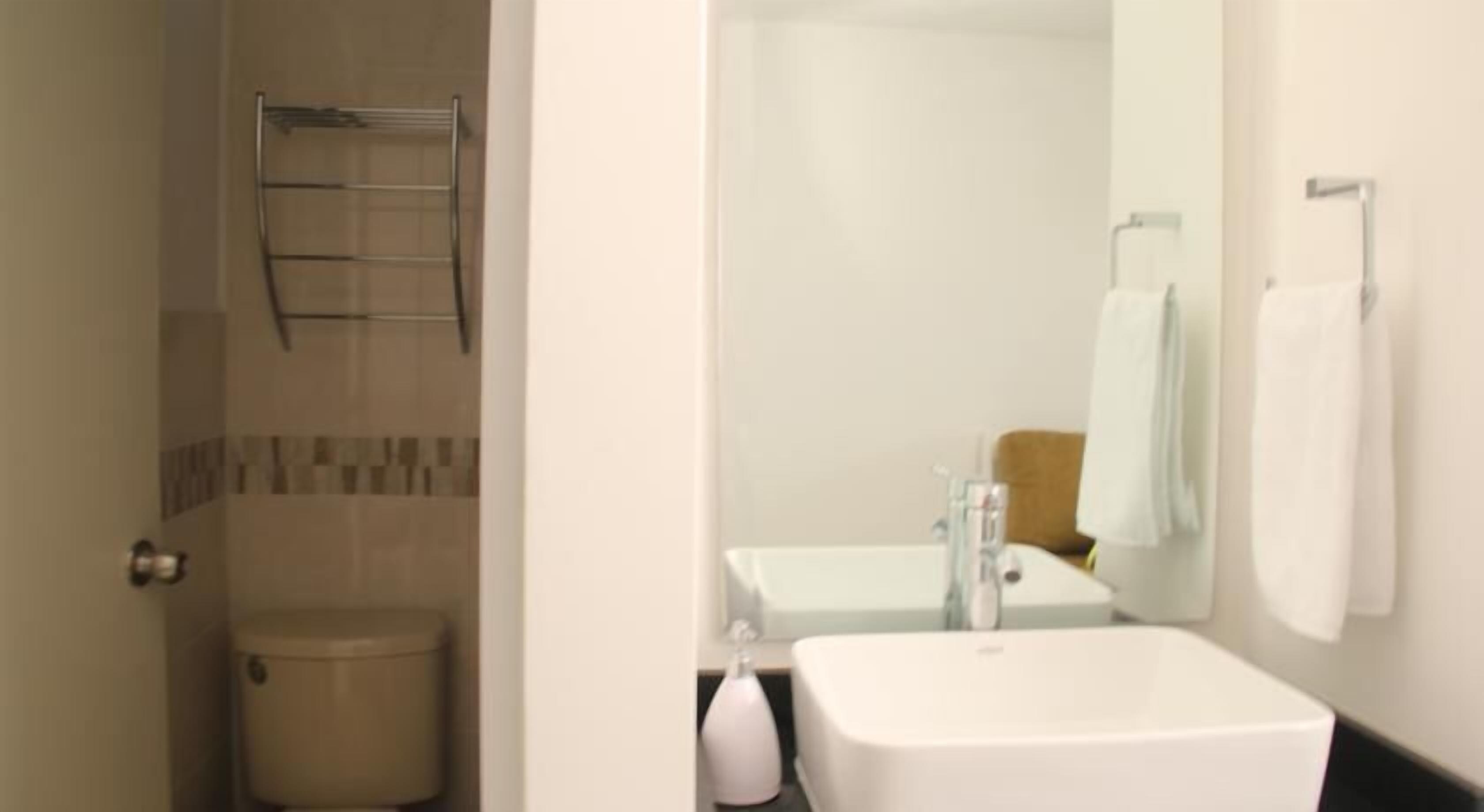 Ein Badezimmer mit Toilette, Dusche, Waschbecken und Spiegel.