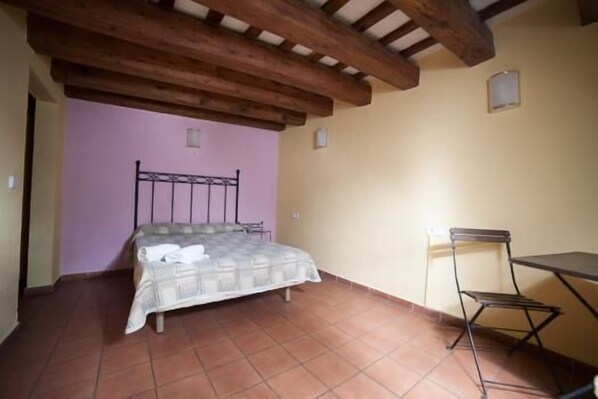 A bedroom with a bed, a chair, and a small table. - Hotel Peninsular (Barcelona)
