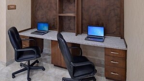 A workspace with two desks, each with a laptop and a black office chair. - La Bonita Inn & Suites (Crane)