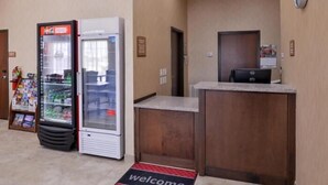 A reception area with a Coca-Cola refrigerator, a vending machine, and a reception desk. - La Bonita Inn & Suites (Crane)