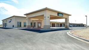 A building with a covered entrance, a sign reading "La Boca", and a parking area. - La Bonita Inn & Suites (Crane)