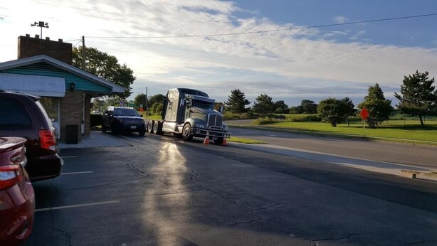 A parking lot with a large truck and a car. - Shiva's Travelers Lodge (Niagara Falls)