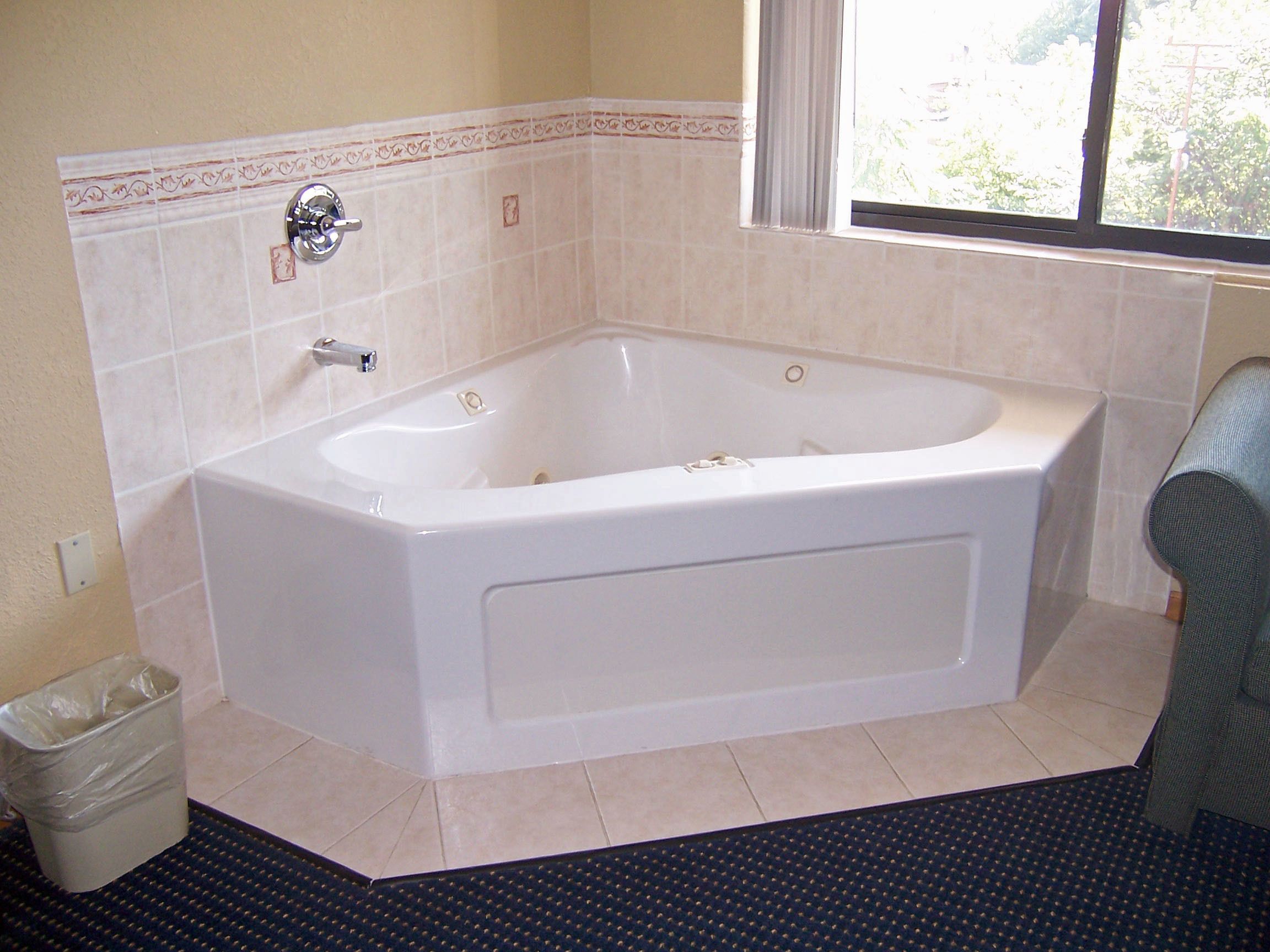 A standard bathroom with a bathtub, a toilet, and a window.