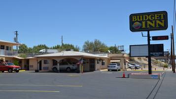 A Budget Inn with a clear entrance, parking area, and a sign indicating vacancy.