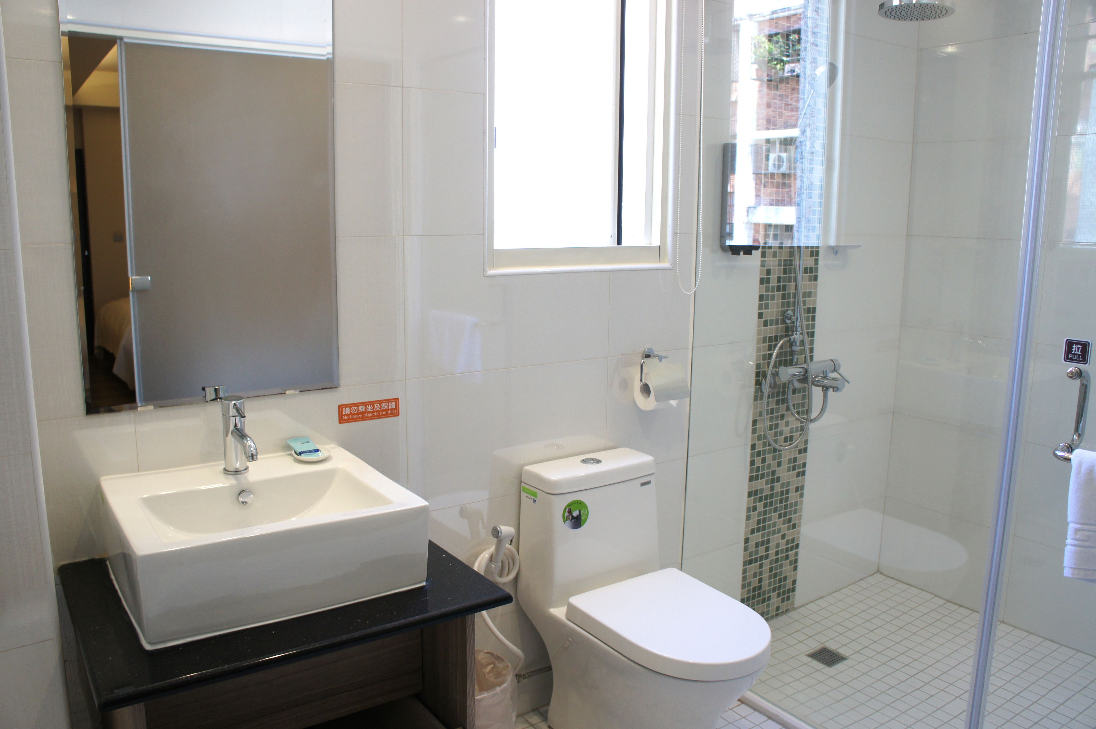 Un baño con lavamanos, inodoro y ducha.