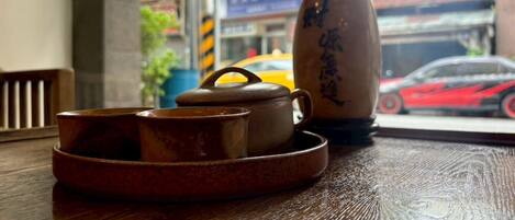 A wooden table with a tea set including a teapot and cups, and a decorative item with calligraphy.
