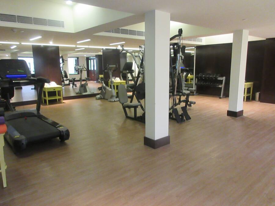 Ein Fitnessstudio mit Laufbändern, Kraftgeräten und Trainingsausrüstung.