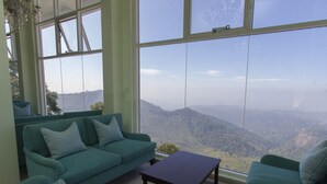 Salón con un amplio ventanal que ofrece vistas a la montaña.