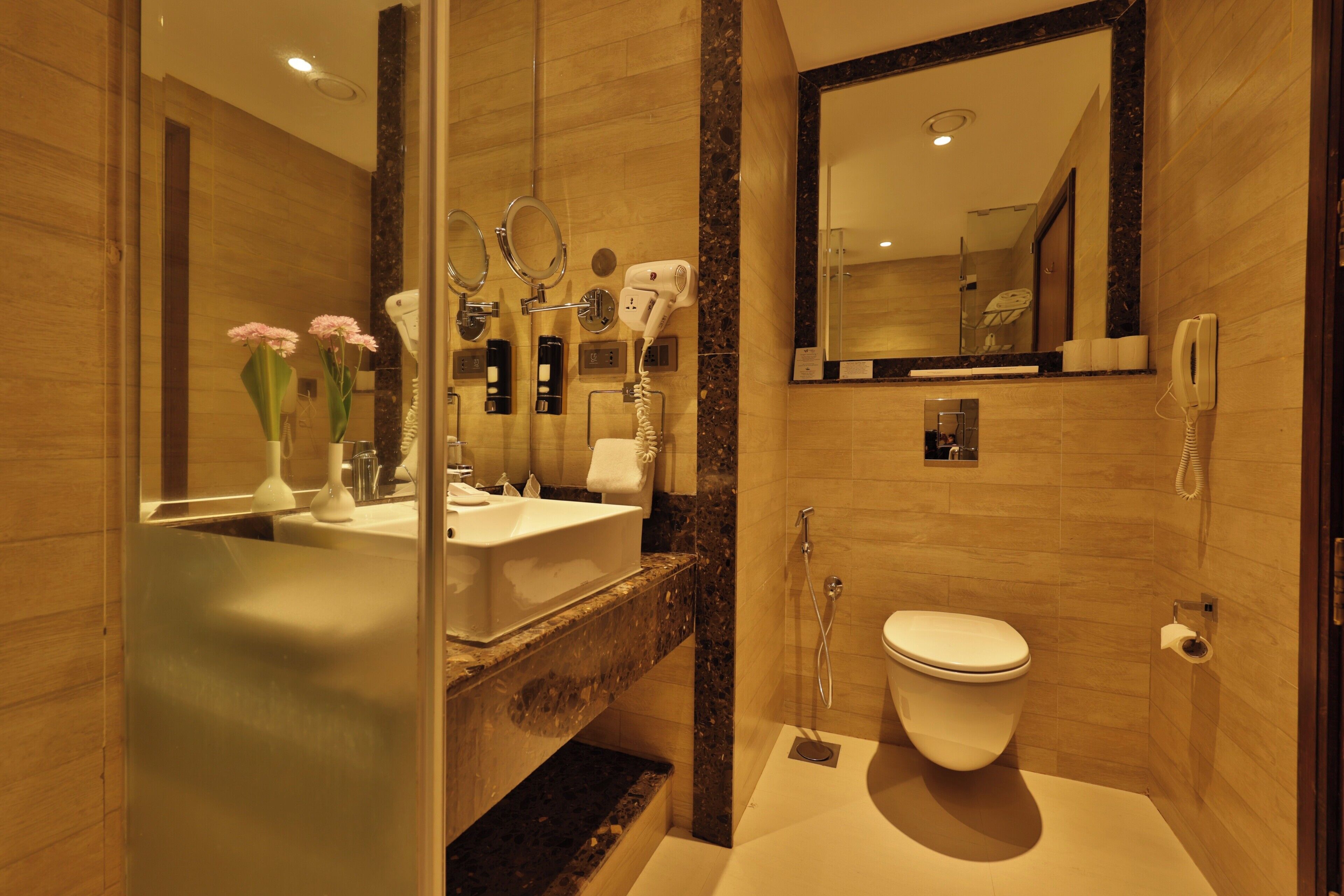 A modern bathroom with a bathtub, toilet, and vanity.