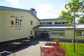 A hotel named "FIT" with outdoor seating and a garden area.